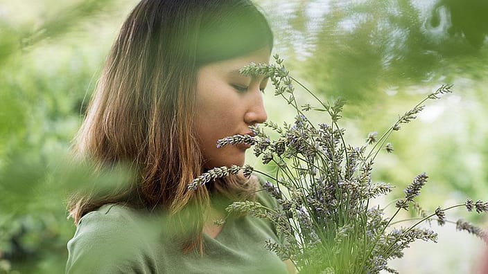 Vrouw die ruikt aan een bloem
