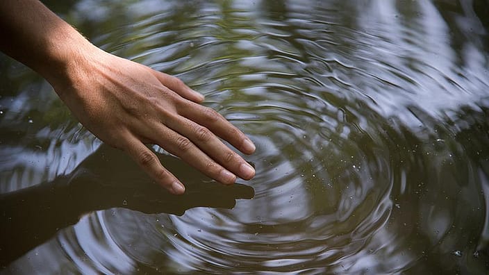 Hand door het water halen