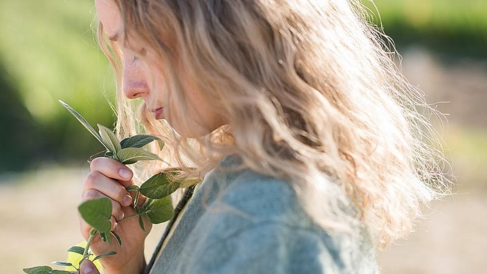vrouw ruikt aan plant