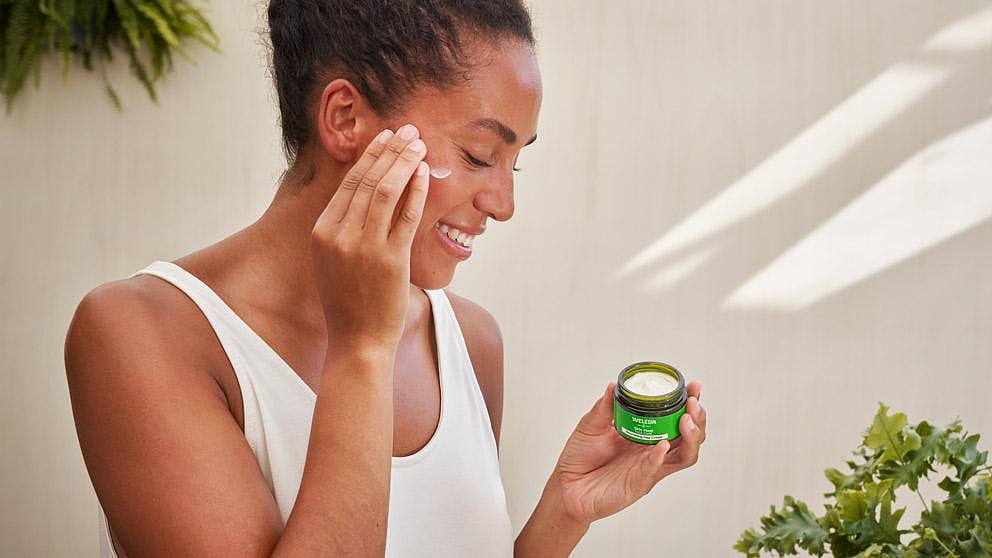 Vrouw smeer Skin Food Voedende Dagcrème op